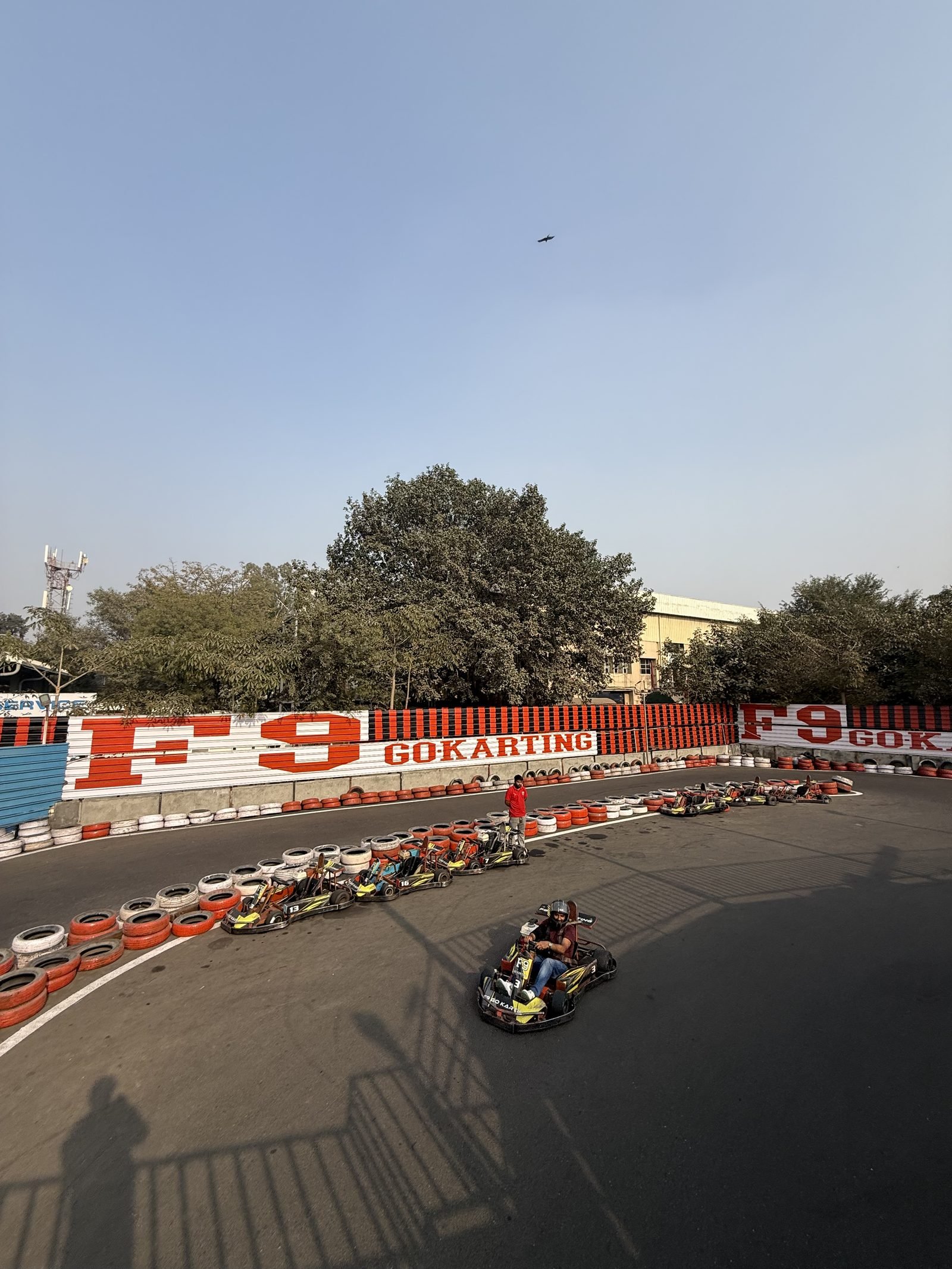 Karts on the track at F9 Go Karting Sector 17/18, with tyre walls and the F9 barrier